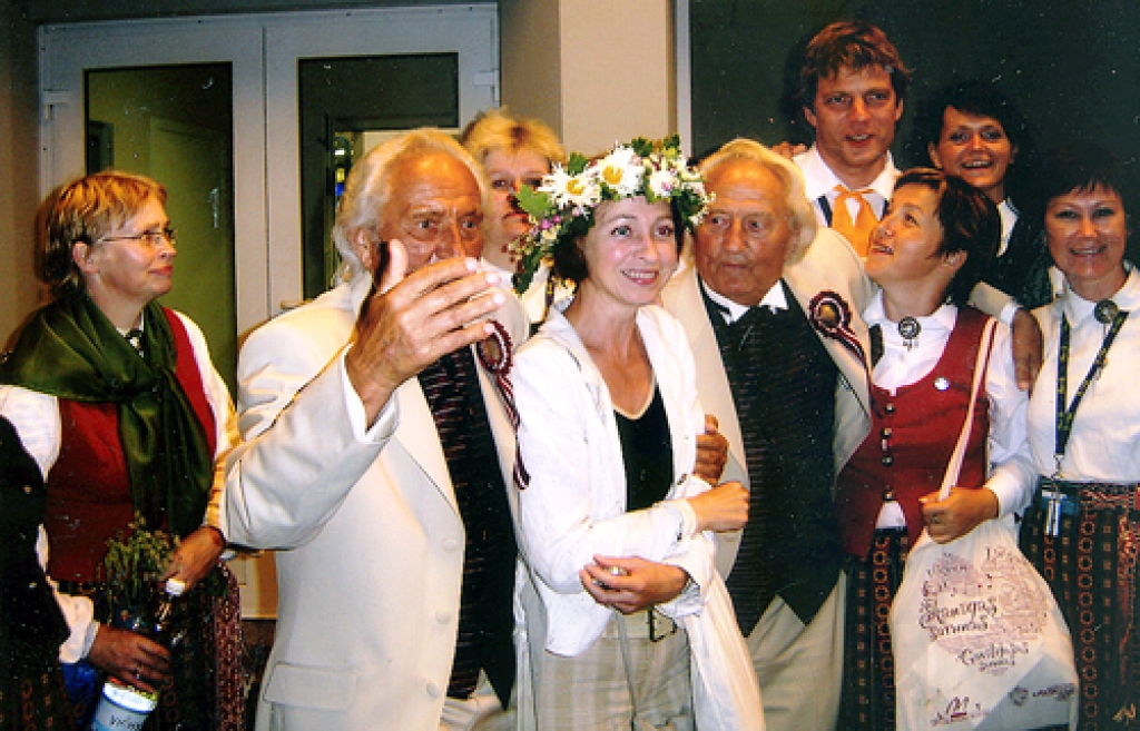 Kora «Mežotne» vadītāja Mārīte Jonkus (vidū) un dziedātāji kopā ar izcilākajiem diriģentiem Imantu un Gido Kokariem.