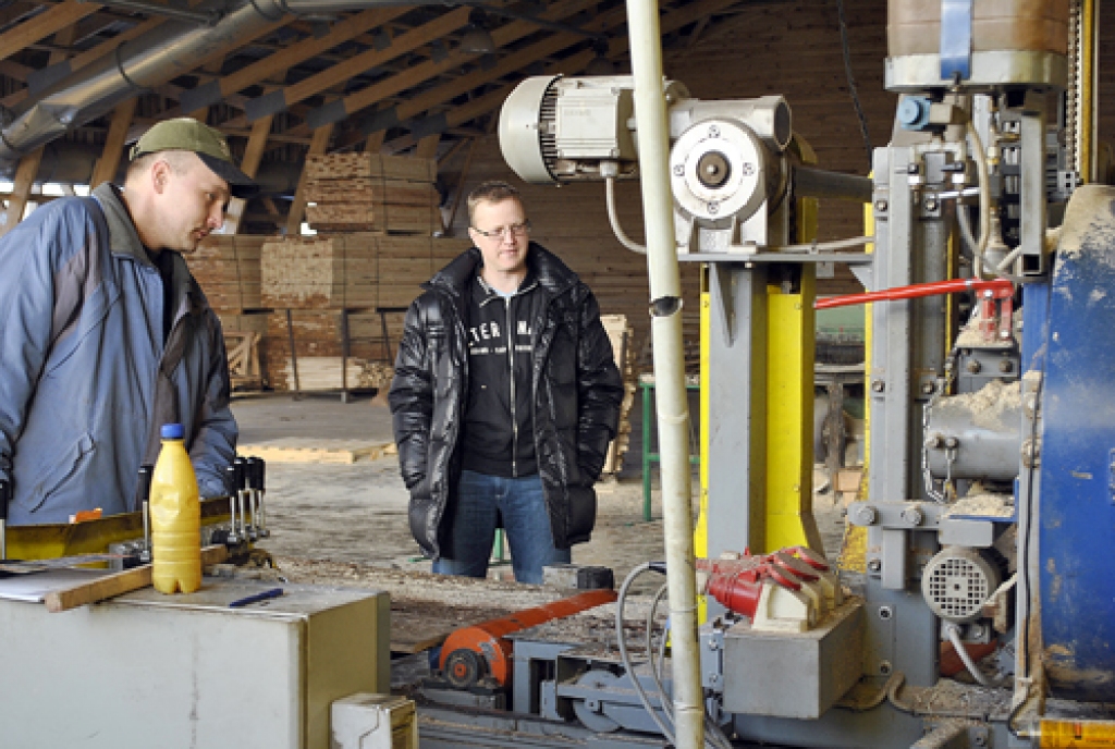 Edgars Keičs (no labās) un lentzāģa operators Raimonds Markevičs apspriež darba procesu. 