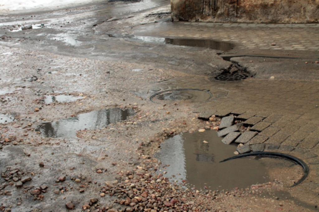 Plūdoņa ielā Bauskā esošās bedres dēļ automašīnas pārvietojas pa trotuāru. 