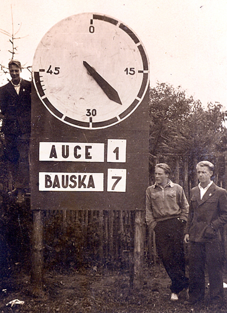 Bauskas stadionā 1948. gadā. Bauskas vidusskolas sportisti (no kreisās) Edmunds Nerets, Elmārs Krūze, Laimonis Šulcs pie stadiona pulksteņa, kura rādītāji bija jābīda ar roku.