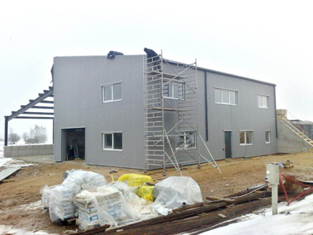 Attīrīšanas iekārtu jaunā ēka ar notekūdeņu rezervuāriem top Iecavas pievārtē.