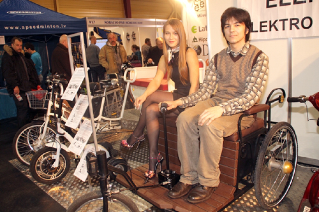 Anastasija Arona un Ivans Sņetkovs demonstrē pēc seno laiku parauga izgatavotu elektrorikšu. 