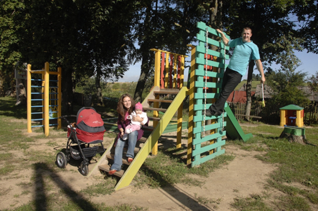 Gita un Jānis Lazdiņi priecājas par atjaunoto bērnu rotaļu laukumu Mežotnes pagasta Ceplī. Tas veikts pērn, izmantojot Nīderlandes fonda «KNHM» finansējumu. 