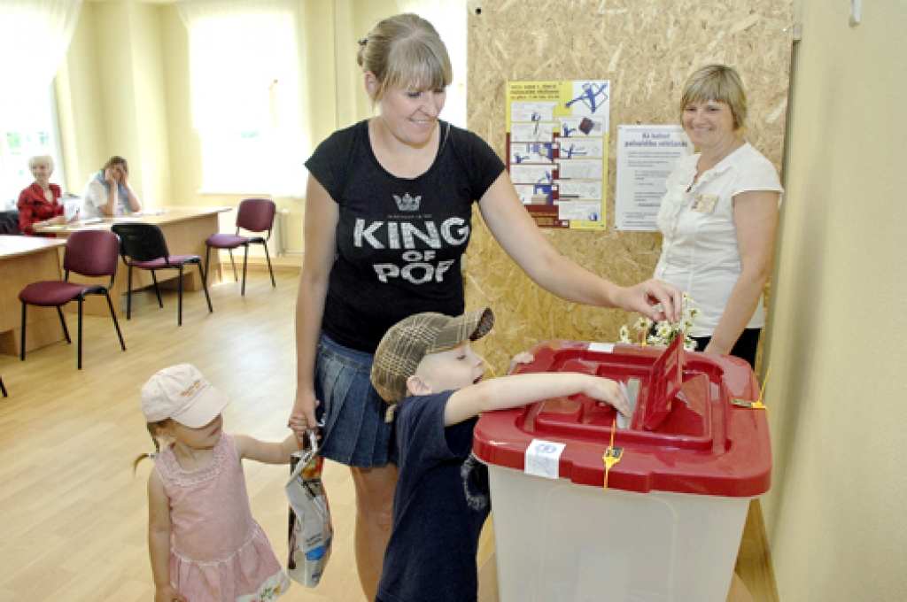 Saulainē bērniem lielu prieku sagādāja vēlēšanu zīmju iemešana kastē. Attēlā – Kristiāns Motiejunas, Laura un Monta Kvedares.