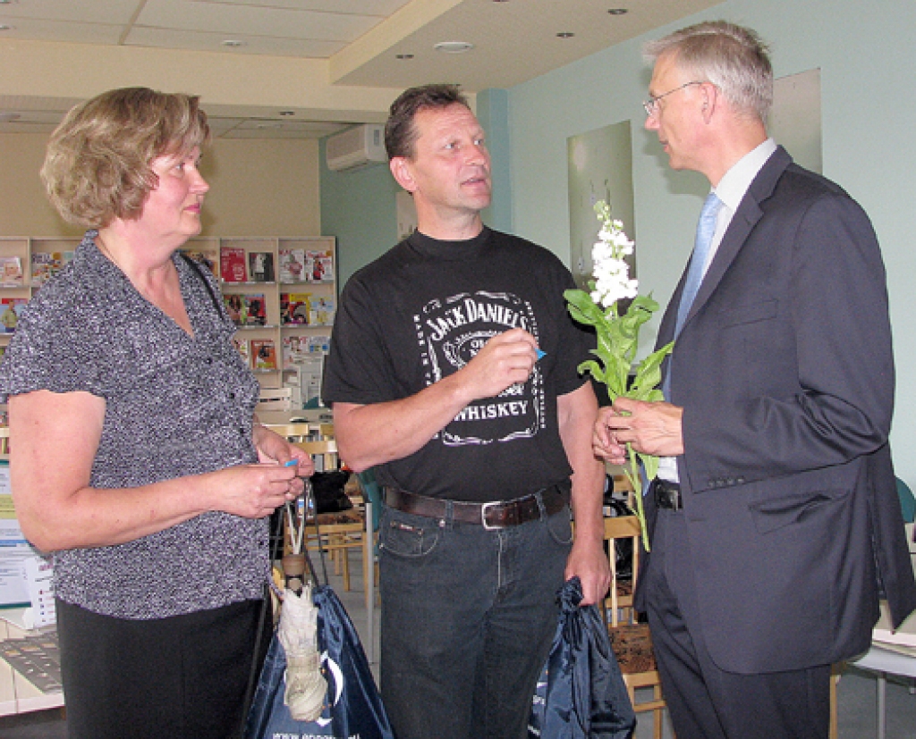 Krišjānis Kariņš, Eiropas Parlamenta deputāts (no labās), sveic konkursa izlozes veiksminieci Mārīti Agrumu un otras braucējas Initas Gilbertes dzīvesbiedru Valdi Raisteru.