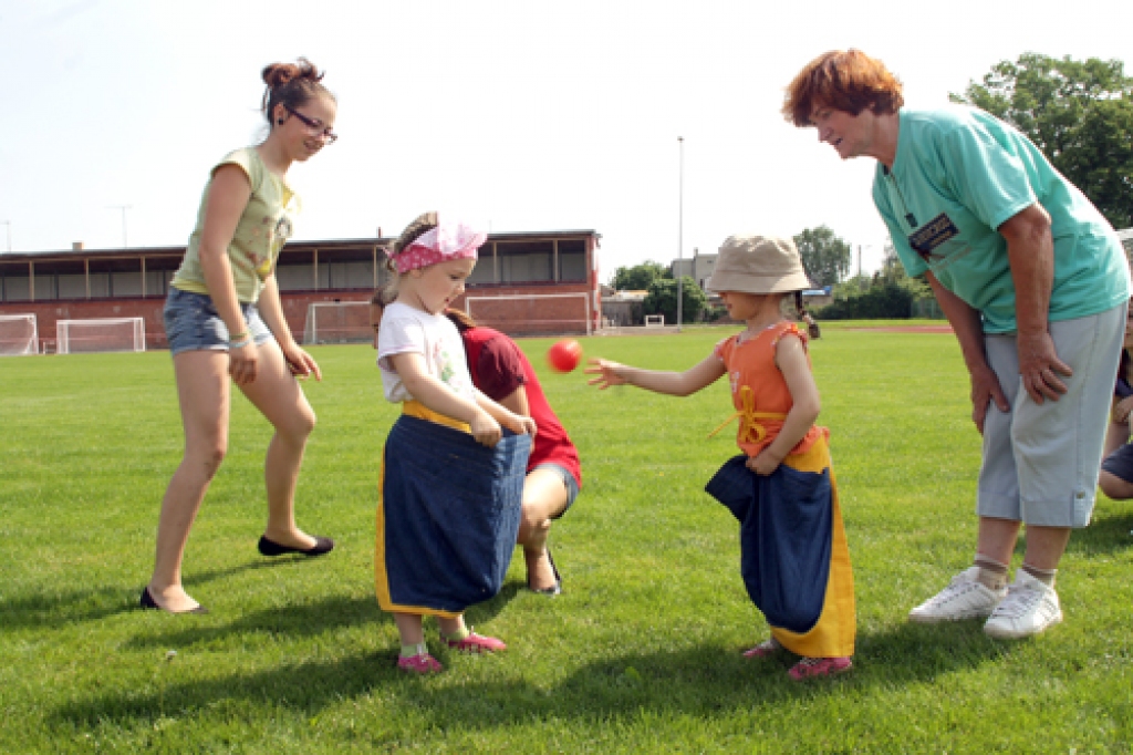Paši jaunākie sportisti izmēģina spēkus bumbiņas mešanā maisā. 