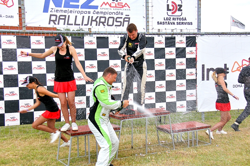 Vasaras vidū rumulēšanās tradīcija no ganībām pārceļas uz autobraucēju goda pjedestāliem, vien izšļakstāmais šķidrums ir krietni saldāks un dzirkstošāks, nekā pavasarī saņem gotiņas un viņu ganiņi.
Autors: Foto – Artūrs Enkurs