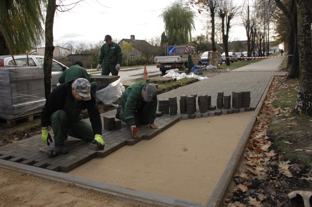 SIA «Vides serviss» strādnieki liek bruģakmens segumu ietvei pie Salātu ielas 12. mājas.
Autors: Ivars Bogdanovs
