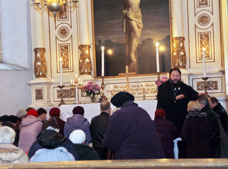 Mācītājs Aivars Siliņš sniedz altāra sakramentu draudzes locekļiem.
Autors: Uldis Varnevičs