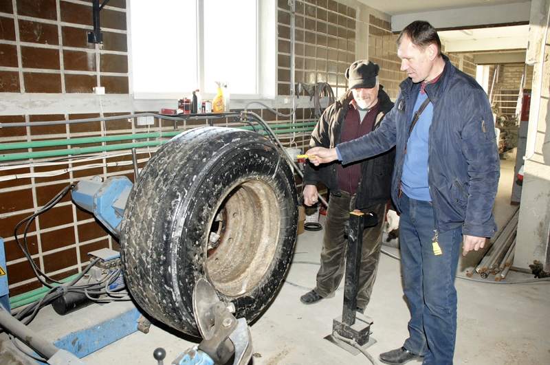 Aigars Miļūns (no labās) un autovadītājs Ilgonis Dzendoleto montē smagās automašīnas riepu.
Autors: Foto – Ivars Bogdanovs