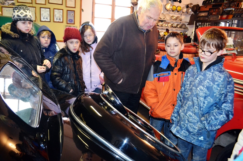 Edgars Gasūns Mūzikas un mākslas skolas audzēkņiem izrāda Retro auto muzeja ekspozīciju, lai to varētu ilustrēt grāmatā.
Autors: Foto no L. Lauskinieces albuma.