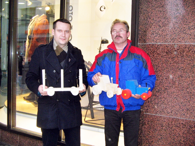 Arnolds Ziemelis (no labās) nodod simboliskos «cerību traktorus» Jānim Karalim, Eiroparlamenta deputātes Sandras Kalnietes palīgam. 2012. gads.
Autors: Foto no «Bauskas Dzīves» arhīva.