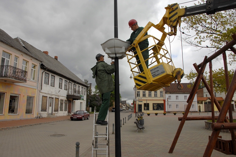 SIA «Vides serviss» strādnieki uzstāda puķu podus pie Rātslaukuma laternām. 

Autors: Ivars Bogdanovs