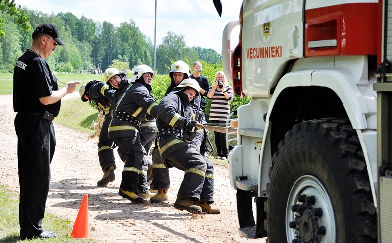 Vecumnieku ugunsdzēsēji ieķērušies virvē, lai no vietas izkustinātu aptuveni 14 tonnu smago automašīnu «Scania».
Autors: Žanna Zālīte