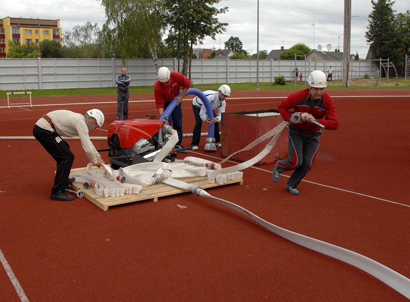 Māris Mincenbergs (no labās) no Bauskas komandas dodas distancē. Pārējie komandas biedri turpina savienot šļūtenes. 
Autors: Ivars Bogdanovs