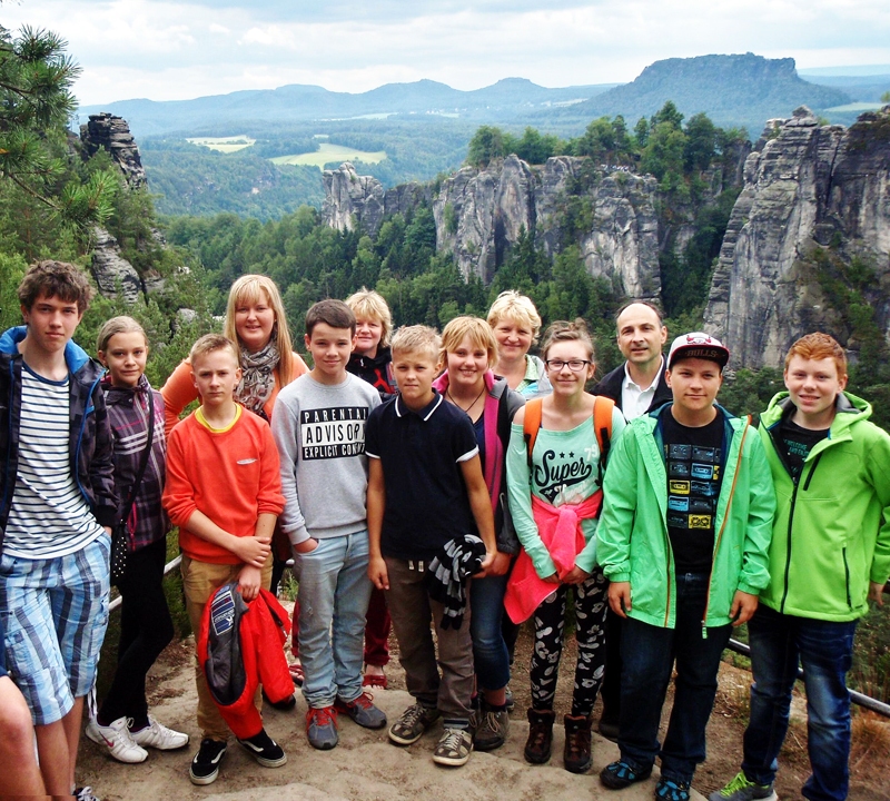 Bastei klintīs Saksijā. No kreisās – skolēnu mācību uzņēmuma «SNK» vadītājs Uldis Urtāns un skolēnu mācību uzņēmuma «Dižkoks» pārstāvji – Airita Skaldere, Matīss Kataņenko, skolotāja Solvita Lauzēja un Jānis Biezais (septītais no kreisās) kopā ar Pirnas uzņēmuma «Schlibbelkiste» darbiniekiem un vecākiem. 
Autors: no personiskā albuma