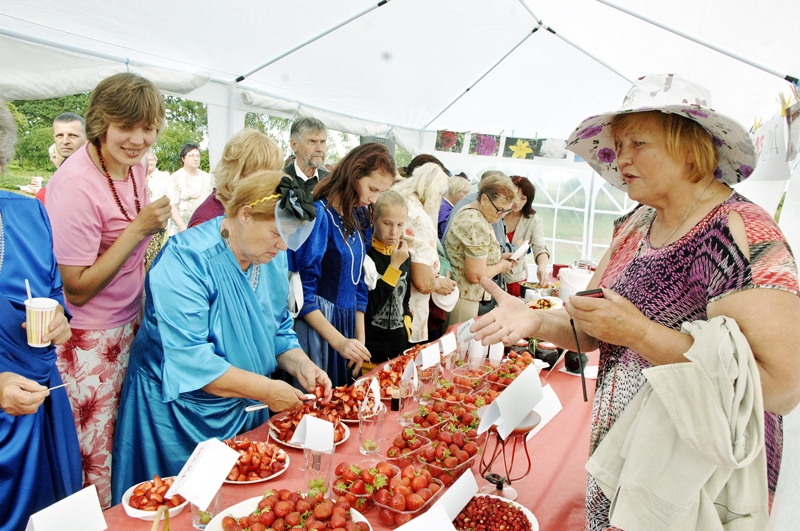 Anna Truntika (no labās) aicina viesus degustēt Latvijas zemenes.
Autors: Ivars Bogdanovs