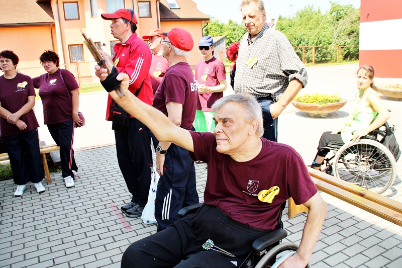 Laimonis Rigasts (priekšplānā) izveidojis rokai speciālu ierīci, lai varētu piedalīties šautriņu mešanas sacensībās.
Autors: Uldis Varnevičs