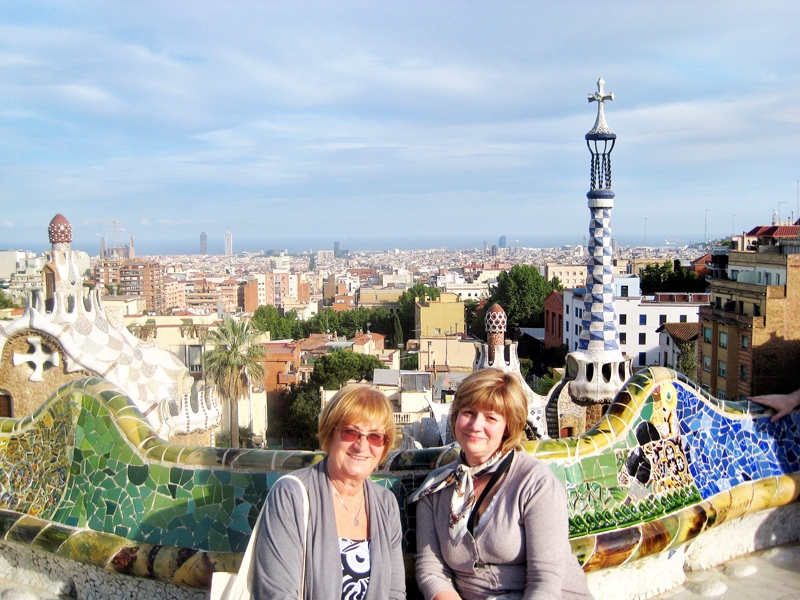 Uz pasaulē garākā sola Gela parkā Inga Muižniece (no kreisās) un ceraukstiete Zinta Cimermane. Fonā arhitekta Antonio Gaudi projektētās ēkas un Barselonas panorāma.
Autors: no personīgā albuma