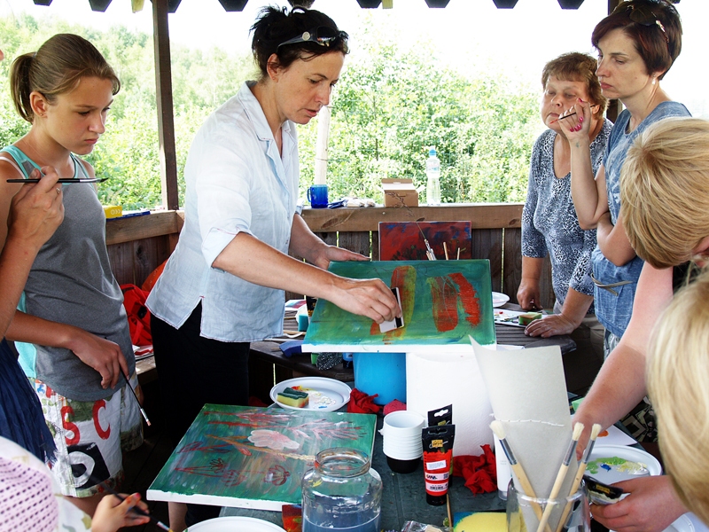 Elga Grīnvalde, gleznotāja (centrā), ierāda, kā krāsa uzklājama un noņemama ar vecu bankas karti.
Autors: Foto – Antra Ērgle