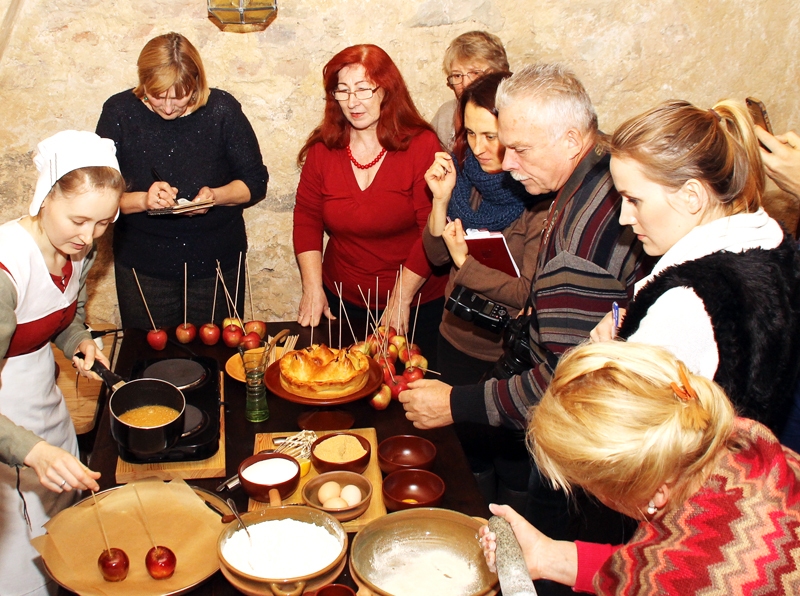 Ilona Ozola (no kreisās) demonstrē karamelizētos ābolus, kas viduslaikos bija populārs izstrādājums. 
Autors: Uldis Varnevičs