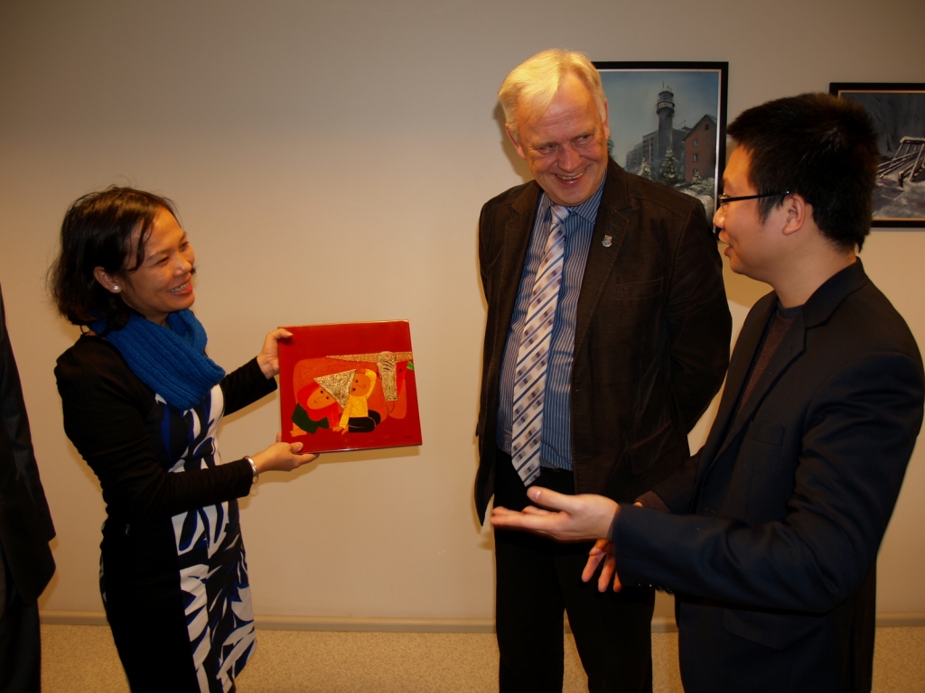 Delegācijas vadītāja Nguena Thi Hai Vana (no kreisās) pasniedza Iecavas novada domes priekšsēdētājam Jānim Pelsim mākslas darbu tradicionālajā vjetnamiešu tehnikā. Tulko Kao Viets Ngujens.
Autors: Antra Ērgle