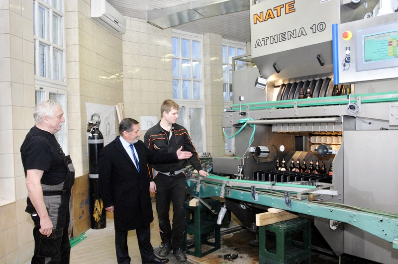 SIA «Bauskas alus» valdes loceklis Vladimirs Barskovs (vidū) kopā ar Čehijas uzņēmuma «NATE» meistaru Vladislavu Mahku (no kreisās) vēro, kā sāk strādāt jaunā stikla pudeļu pildīšanas līnija. 
Autors: Ivars Bogdanovs