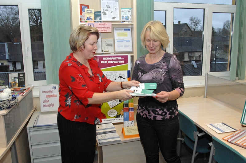 Bauskas Centrālās bibliotēkas Biznesa bibliotēkas vadītāja Ērika Pelcere lasītājai Dainai Biķerniecei pasniedz Tiesībsarga biroja dāvāto kalendāru. 
Autors: Ivars Bogdanovs