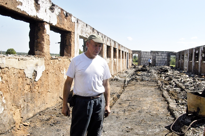 Andris Kalniņš pie 2007. gadā nodegušās fermas, kad tajā iespēris zibens.