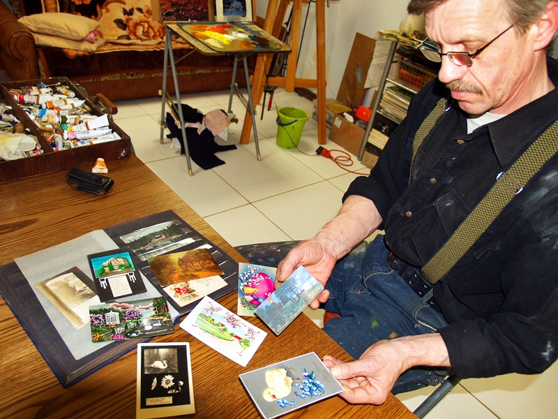 Andris Grudauskis rāda, cik daudzveidīgas laika gaitā bijušas atklātnes un apsveikuma kartītes. 
Autors: Antra Ērgle