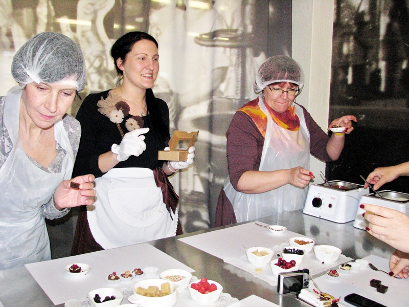 Linda Abarone, muzeja gide (centrā), ikvienu iemācīs gatavot šokolādes konfektes.
Autors: Vilnis Auzāns