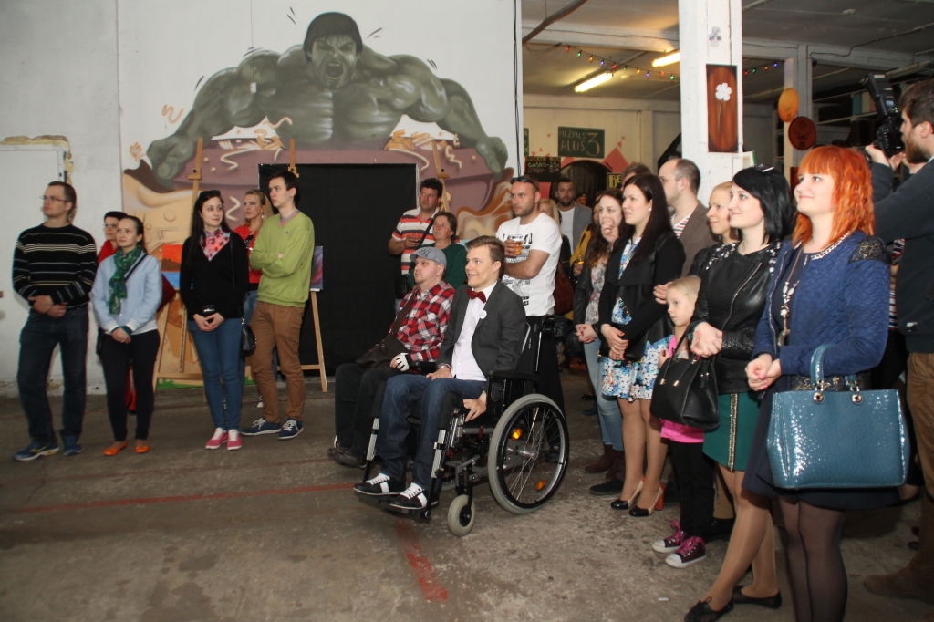 Mareks Odumiņš (ratiņkrēslā no labās) priecājas par izstādei veltīto atsaucību. 
Autors: Uldis Varnevičs