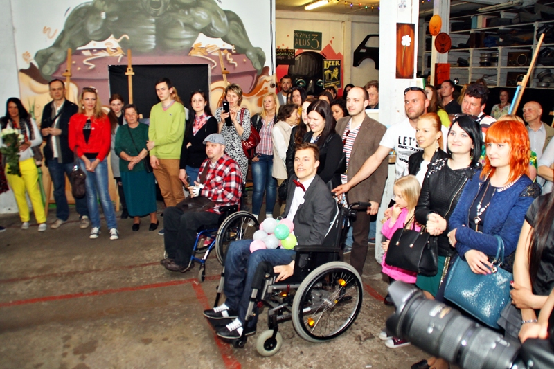 Izstādes atvēršana Rīgā pagājušajā nedēļā. Mareks Odumiņš (ratiņkrēslā no labās) priecājas par lielo atsaucību.
Autors: Uldis Varnevičs