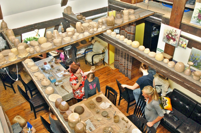 Keramikas darbnīcā ir darbīga un ģimeniska gaisotne. Plenēristu izveidotie māla podi sarindoti žūst.
Autors: Ivars Bogdanovs