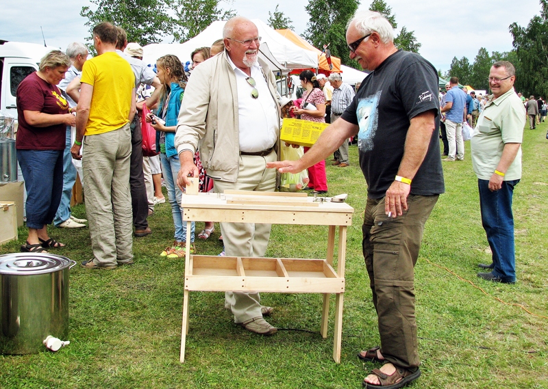 Bitenieks no Bauskas Jānis Bite (centrā) ar kolēģi līgatnieku Pēteri Lideri pārlūko jauno pirkumu – rāmīšu iešūnošanas galdu.
Autors: Vilnis Auzāns