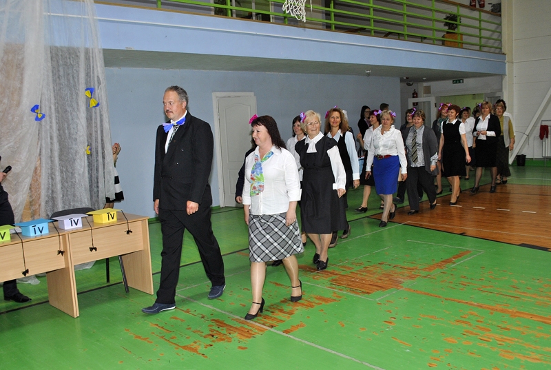 Īslīces vidusskolas zālē svinīgā ierindā iesoļo šīs dienas absolventi – skolas pedagogi. 
Autors: Ivars Bogdanovs