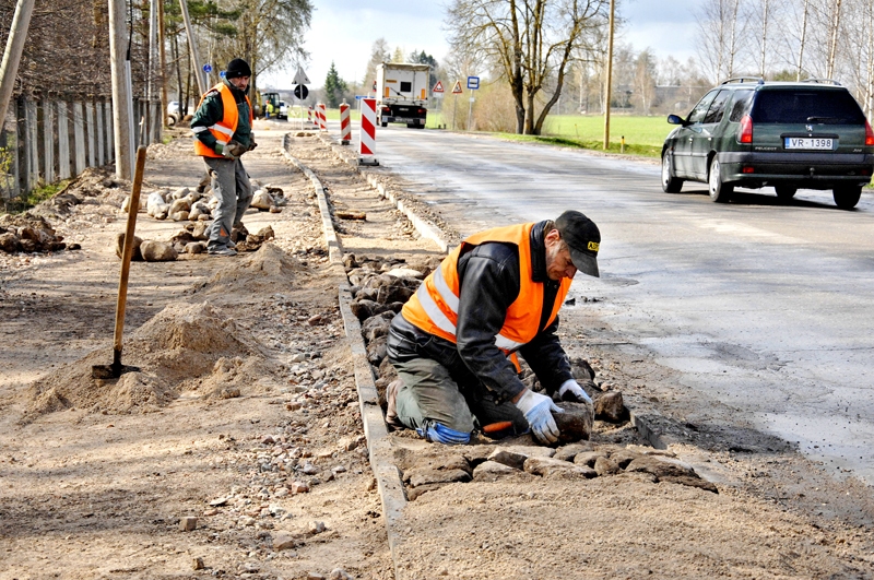 Uzņēmuma «Viona» strādnieks Edmunds Šimkūns (priekšplānā) kopā ar kolēģiem turpina pērn sāktā gājēju un velosipēdistu celiņa izbūvi no Bauskas uz Īslīces pagasta Rītausmām. 
Autors: Ivars Bogdanovs