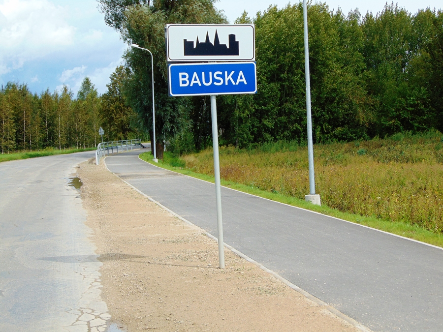 Divu ceļa zīmju apvienojums norāda, ka sākas apdzīvota vieta, šajā gadījumā – pilsēta. Baltā plāksnīte noteic, ka maksimālais braukšanas ātrums ir 50 km/h. Savukārt zilā plāksnīte informē par apdzīvotās vietas nosaukumu.
Autors: Vilnis Auzāns