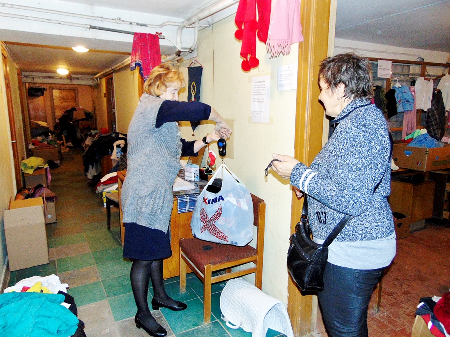 Lilija Patmalniece-Mustermane, sociālās darbinieces palīdze (no kreisās), sver atlasīto drēbju saini. Ir noteikts, ka par kilogramu humānā apģērba jāsamaksā desmit centu.
Autors: Vilnis Auzāns