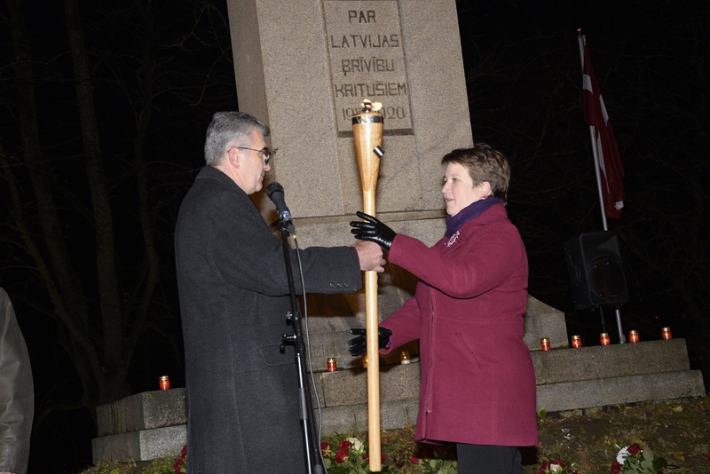 Bauskas novada domes priekšsēdētājs Raitis Ābelnieks svinīgi pasniedz lāpu Jaunjelgavas novada domes deputātei Evijai Vectirānei. Nākamajā rudenī pasākums «Latviešu karavīrs laikmetu griežos» notiks Jaunjelgavā. 
Autors: Ivars Bogdanovs