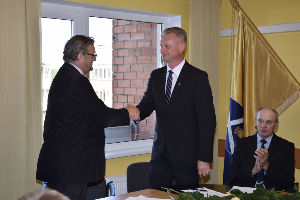 Aivars Mačeks (no labās) bija vienīgais priekšsēdētāja  amata kandidāts un saņēma visu 15 deputātu atbalstu. Ar ievēlēšanu amatā viņu sveic Iecavas novada vēlēšanu komisijas priekšsēdētājs Tālrīts Krastiņš.
Autors: Ivars Bogdanovs