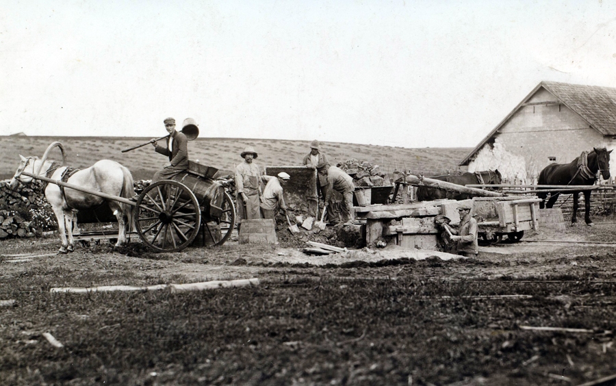 Mežotnes ķieģeļu ceplis. Kreisajā pusē balts zirgs, iejūgts divričos, kuros novietota ūdens muca, uz tās sēž vīrietis ar smeļamo kausu rokās. Labajā pusē    divi zirgi iejūgti mālu maļamajā ierīcē, vagonetes, fonā lauks. 20. gadsimta 30. gadi.
Autors: no Bauskas muzeja krājuma