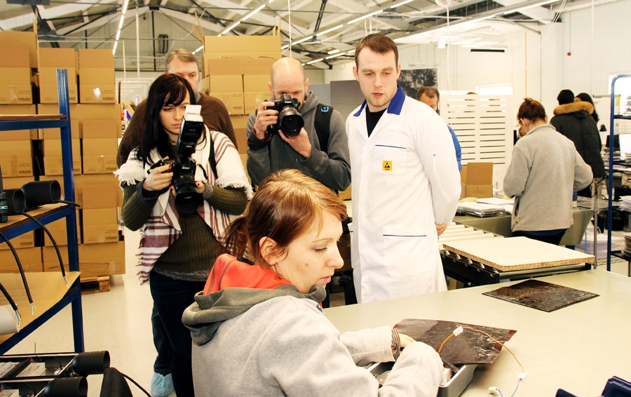 Elvis Holsts (stāv centrā) izrāda žurnālistiem SIA «Vizulo» lampu montēšanas nodaļu. Tuvplānā LED lampu pirms iepakošanas pārbauda un programmē iecavniece Līga Solodilova.
Autors: Uldis Varnevičs