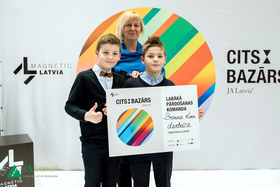 Jaunie uzņēmēji Maikls (no kreisās) un Braiens Burmistrovi kopā ar skolotāju Agitu Barkovu.
Autors: no JAL albuma