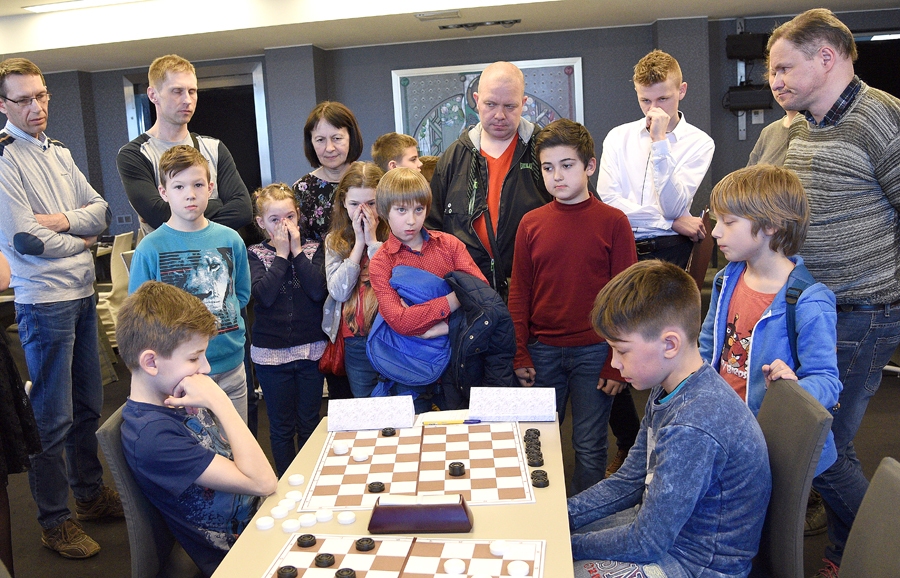 Izšķirošā cīņa. Jāņa Rumbas (pie galdiņa no labās) un Jurģa Stīpnieka cīņa pie pirmā galdiņa. Spēli vēro gan treneri, gan dambretes interesenti.
Autors: Uldis Varnevičs