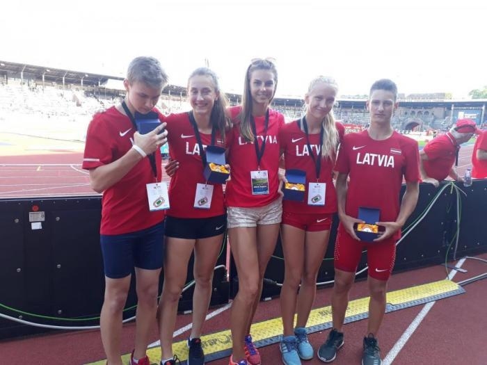 Jorens Maskals (no kreisās), Annija Miļūna, Arvis Sūna (no labās) un Gerda Kerija Dreimane Stokholmā ar komandas vadītāju Solvitu Dzilnavu un izcīnītajām zelta godalgām.
Autors: No albuma.