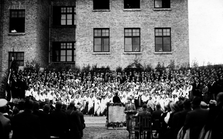 Dziesmu svētku dalībnieki un skatītāji pie Bauskas Valsts ģimnāzijas ēkas pagalma pusē. Kori diriģē Teodors Reiters, 1938. gadā.
Autors: no Bauskas muzeja krājuma