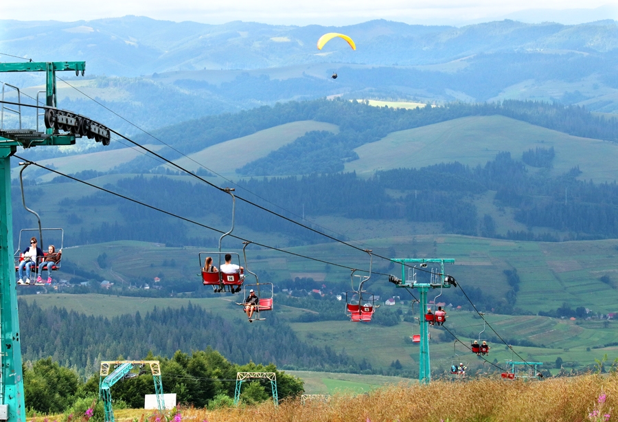 Kad ar pacēlāju devāmies uz Gemba kalna virsotni, zem saviem sēdekļiem varējām vērot kalnu pļavas, pārklātas ar  melleņu krūmiem, avenājiem, priecājāmies par dižskābaržu audzēm.
Autors: Jūnass Palms