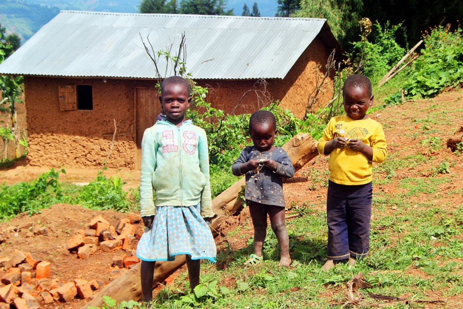 Bērni priecājas par saņemtajām konfektēm. Fonā viņu māja.
Autors: Raitis Ābelnieks