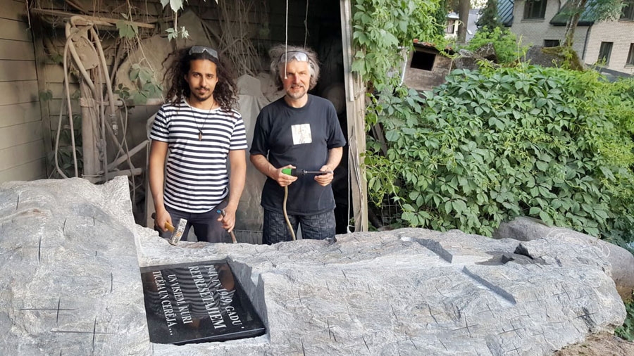 Pieminekli veido mākslinieks Tālivaldis Muzikants (no labās) kopā ar dēlu Emīlu Kristiānu, kurš mācās Latvijas  Mākslas akadēmijā  par  tēlnieku un palīdzēja tēvam pieminekļa tapšanā.  Akmens augstums 3,30 m un platums 1,55 m.
Autors: no draudzes arhīva